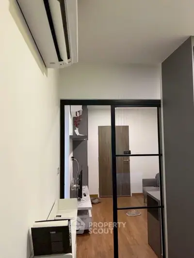 Modern apartment interior with sleek sliding glass doors and stylish decor, featuring a cozy living area.