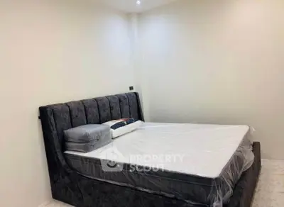 Spacious bedroom with modern bed and neutral decor, perfect for relaxation and comfort.