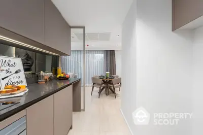 Modern kitchen with sleek cabinetry leading to a stylish dining area with natural light.