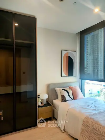 Modern bedroom with sleek design, large window, and stylish decor in urban apartment.