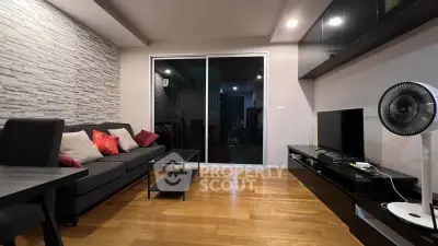 Modern living room with sleek furniture and wooden flooring, featuring a stylish entertainment center and cozy seating.