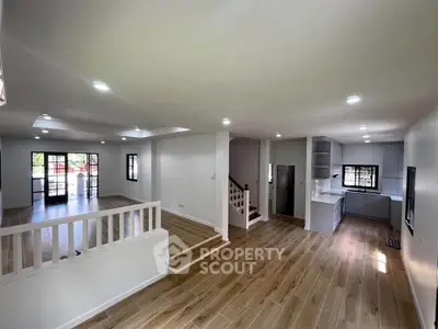 Spacious open-plan living room with modern kitchen and wooden flooring