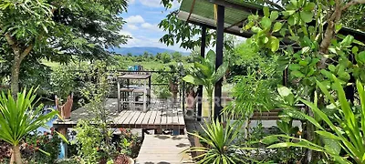 Stunning garden view with lush greenery and wooden deck, perfect for outdoor relaxation.