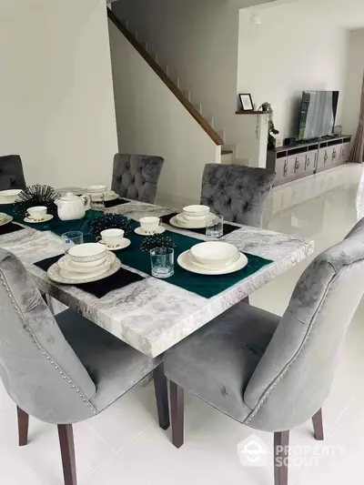 Elegant dining area with marble table and plush chairs in modern home