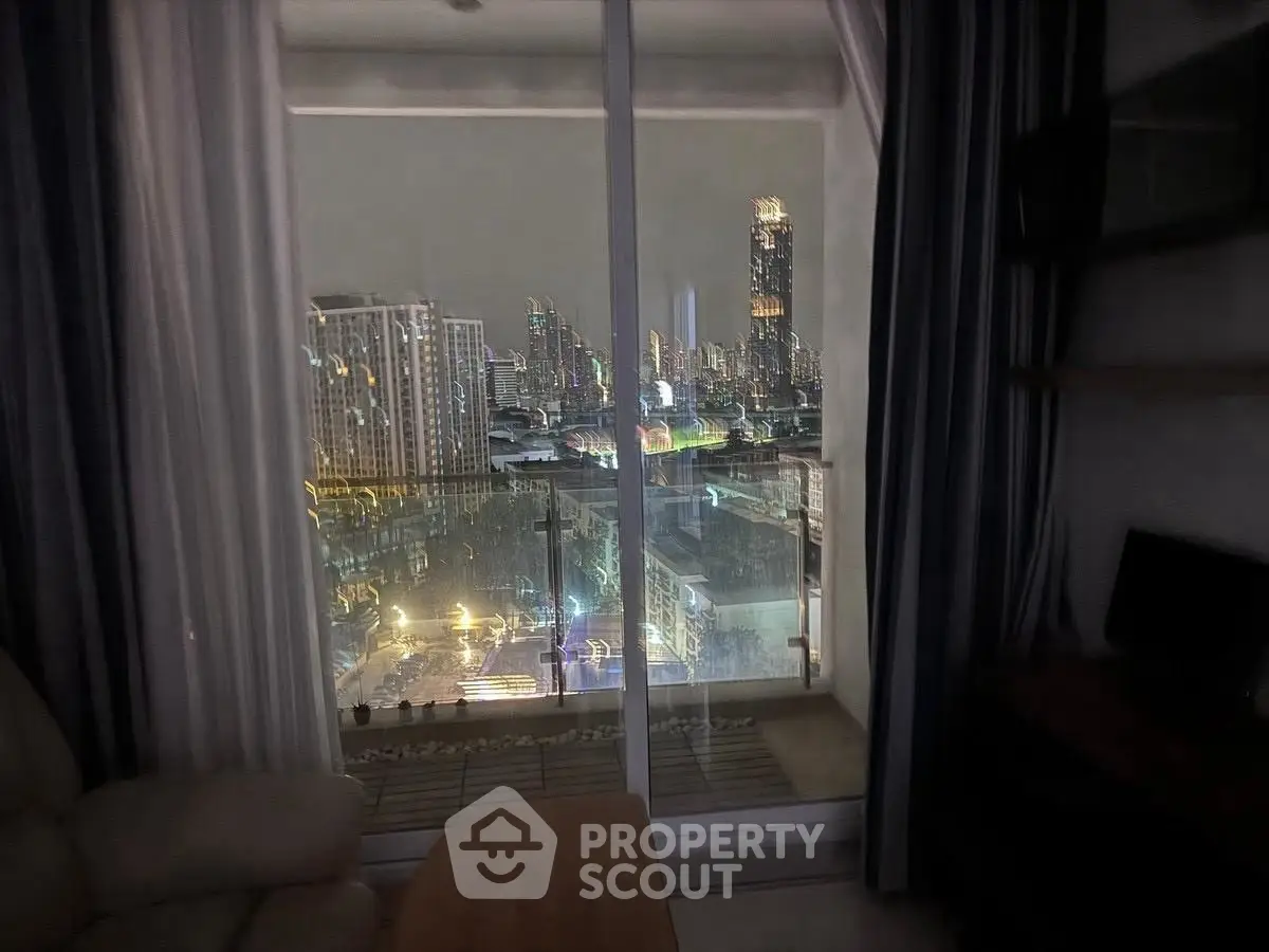 Stunning city view from modern apartment balcony at night, showcasing vibrant skyline lights.