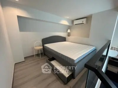 Modern bedroom with sleek design and built-in storage under bed, featuring air conditioning.