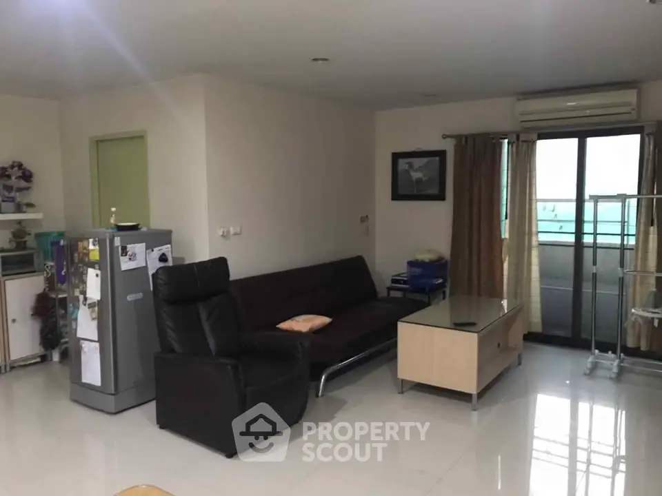 Spacious living room with modern furniture and balcony access