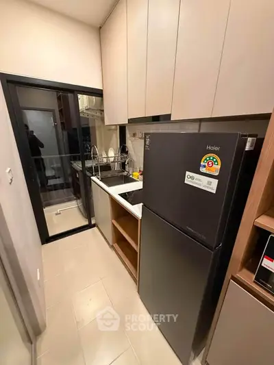 Modern kitchen with sleek appliances and ample storage in a compact layout.