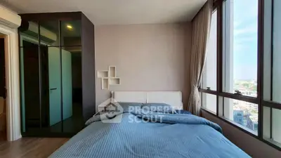 Modern bedroom with large windows offering city views and stylish decor.