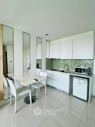 Modern kitchen with sleek white cabinets and mosaic backsplash