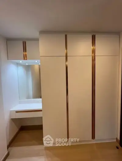 Modern bedroom with sleek built-in wardrobe and vanity mirror