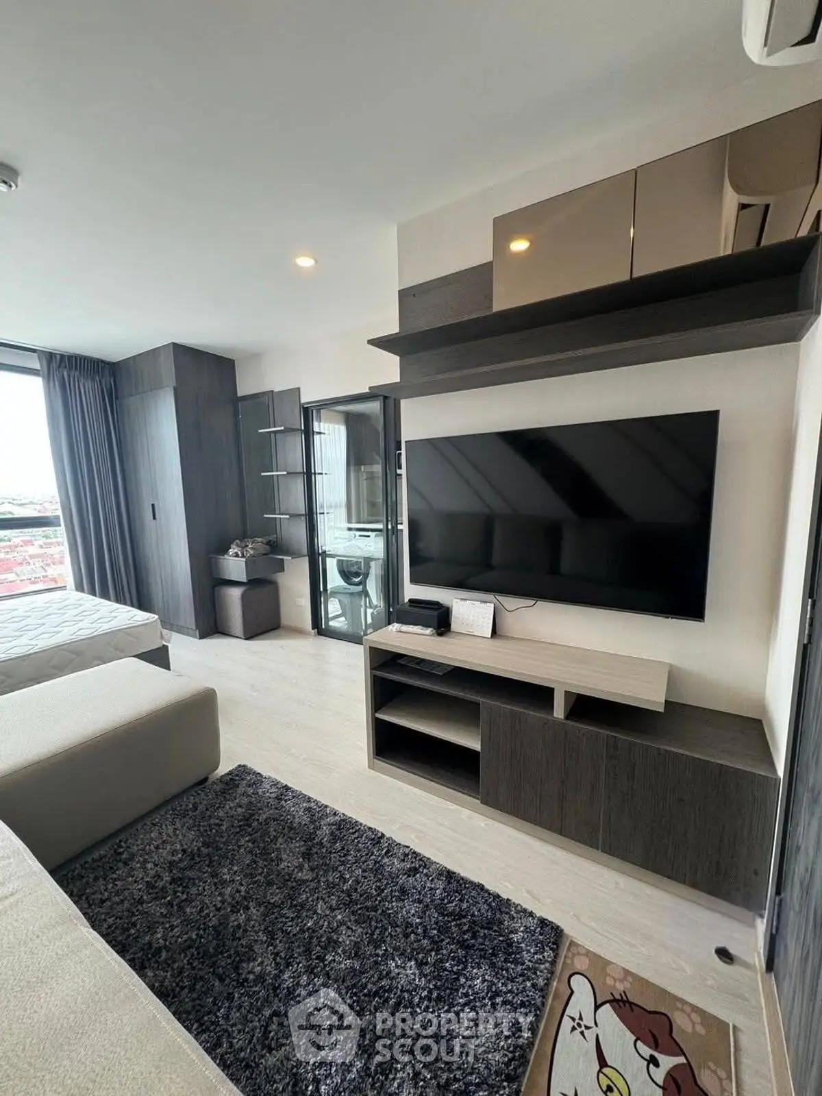 Modern living room with sleek TV setup and stylish furniture in a contemporary apartment.