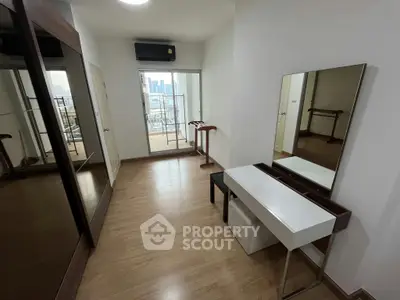 Spacious bedroom with balcony access and modern furnishings in urban apartment