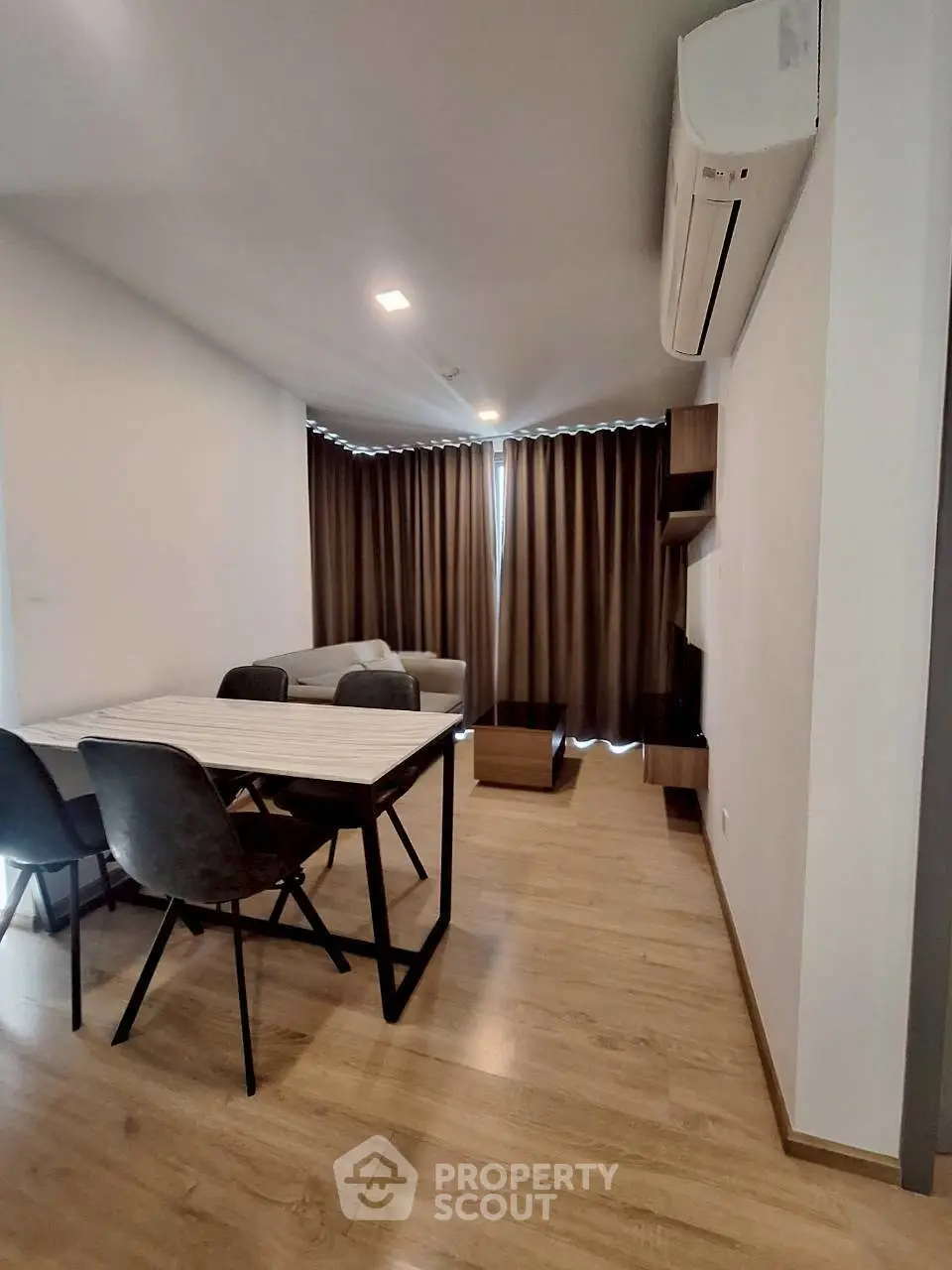 Modern living room with dining area, featuring sleek furniture and wooden flooring.
