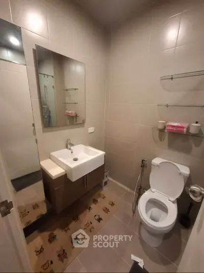 Modern bathroom with sleek fixtures and neutral tiles, featuring a stylish vanity and wall-mounted shelves.