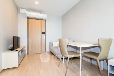 Modern living room with sleek furniture and wooden flooring, featuring a cozy sofa and dining area.