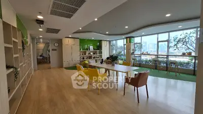 Spacious modern open-plan living area with sleek kitchen, large windows, and stylish dining set, perfect for entertaining and relaxation.