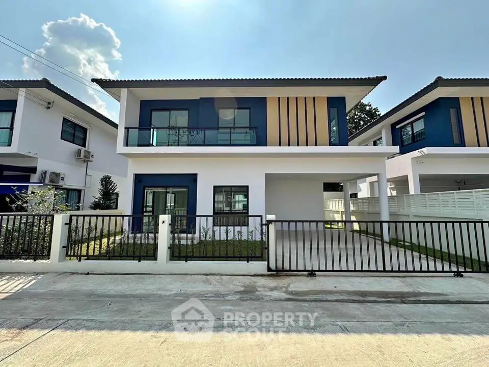 Modern two-story house with sleek design and spacious driveway in a suburban neighborhood.