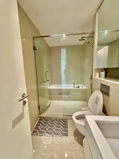 Modern bathroom with glass shower and bathtub in sleek apartment