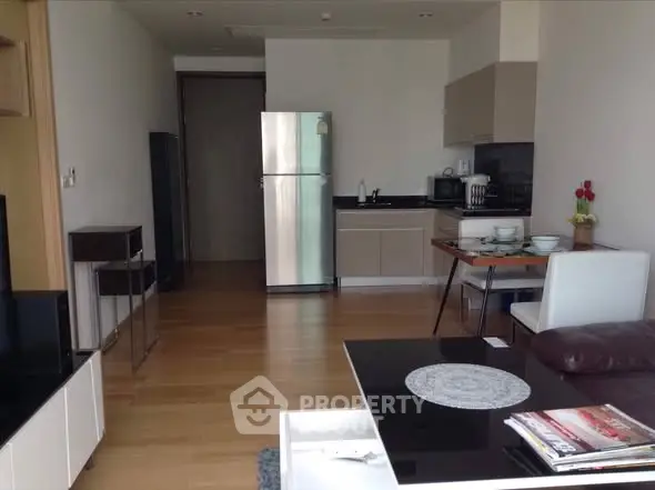 Modern open-layout kitchen with sleek appliances and cozy dining area in stylish apartment.
