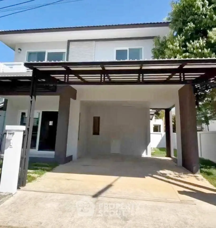 Modern two-story house with covered carport and lush greenery