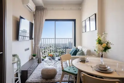 Modern living room with city view, stylish decor, and cozy dining area