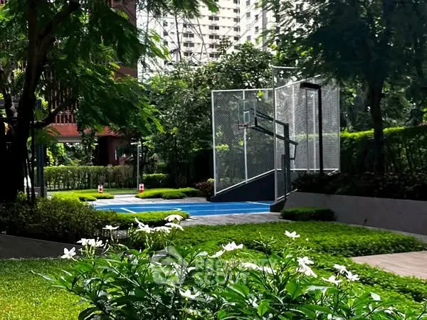 Lush garden with basketball court in modern residential complex.