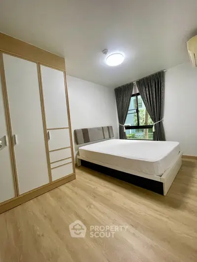 Spacious bedroom with modern wardrobe and large window view