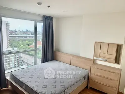 Modern bedroom with city view, featuring a wooden bed and dresser, large window with curtains.