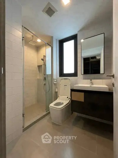 Modern bathroom with glass shower and sleek fixtures in a contemporary apartment.