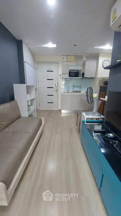 Modern studio apartment with sleek kitchen and cozy living area, featuring contemporary furnishings and stylish decor.