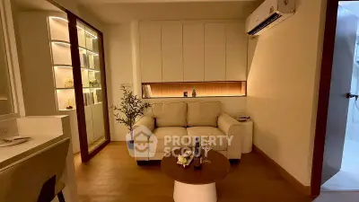 Cozy modern living room with stylish lighting and comfortable seating, perfect for relaxation.