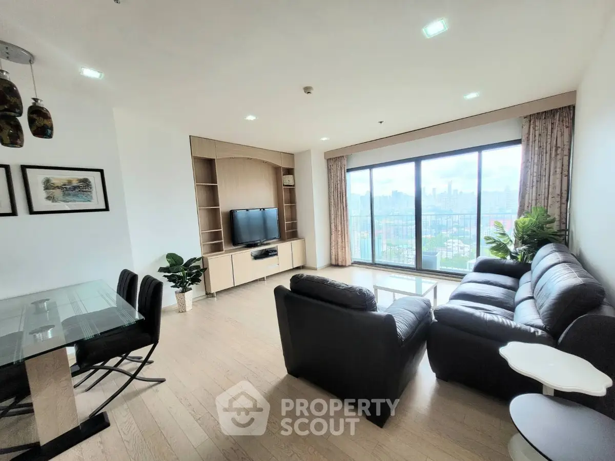 Spacious living room with city view, modern furniture, and natural light