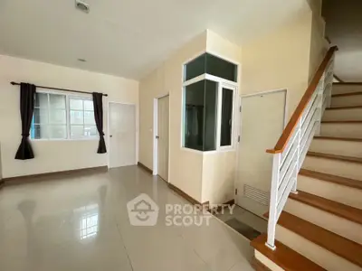 Spacious interior with staircase and large window, ideal for modern living