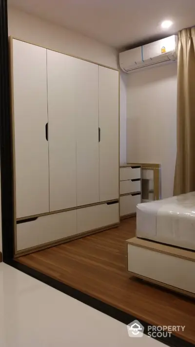 Modern bedroom with sleek wardrobe and air conditioning unit