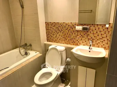 Modern bathroom with bathtub and stylish mosaic tiles, perfect for relaxation and comfort.