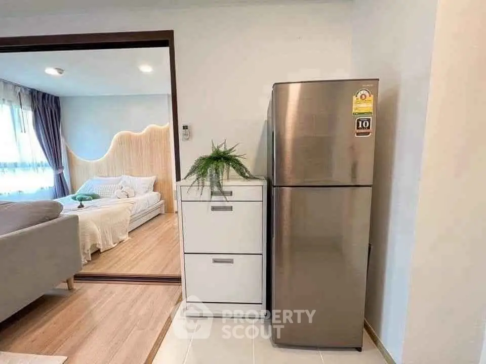 Modern apartment interior with stylish living room and stainless steel fridge