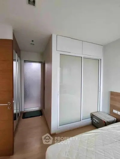 Modern bedroom with sliding closet doors and wooden flooring