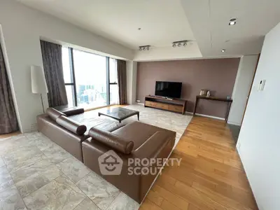 Spacious modern living room with leather sofa and city view, perfect for urban living.