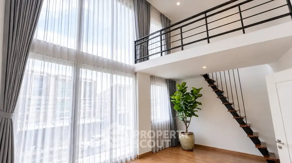 Spacious modern living room with high ceilings and mezzanine in luxury apartment.