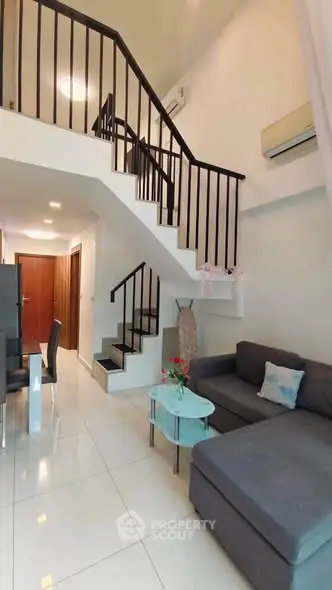 Modern duplex living room with sleek staircase and cozy seating area, perfect for stylish urban living.