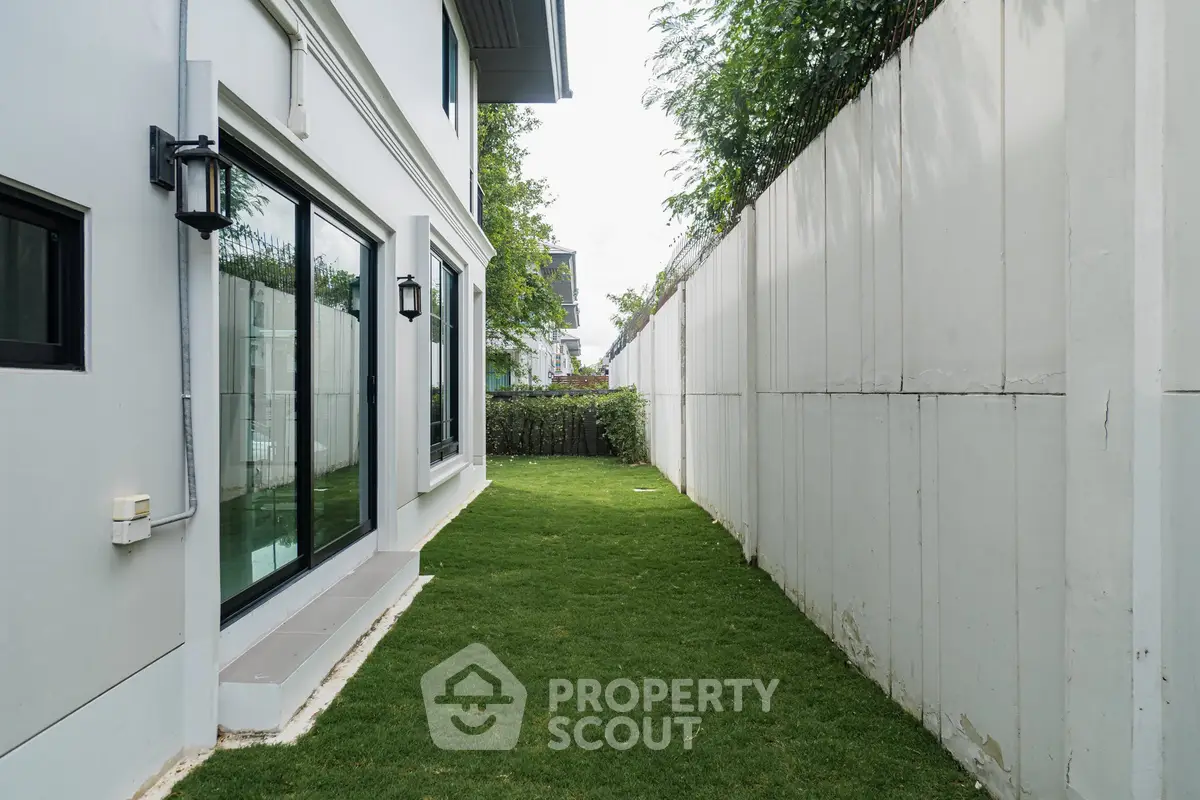 Modern home exterior with lush green lawn and sleek glass doors