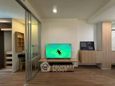 Modern living room with sleek wooden furniture and large TV, perfect for relaxation and entertainment.