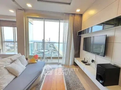 Modern living room with stunning city and river view, featuring sleek furniture and floor-to-ceiling windows.