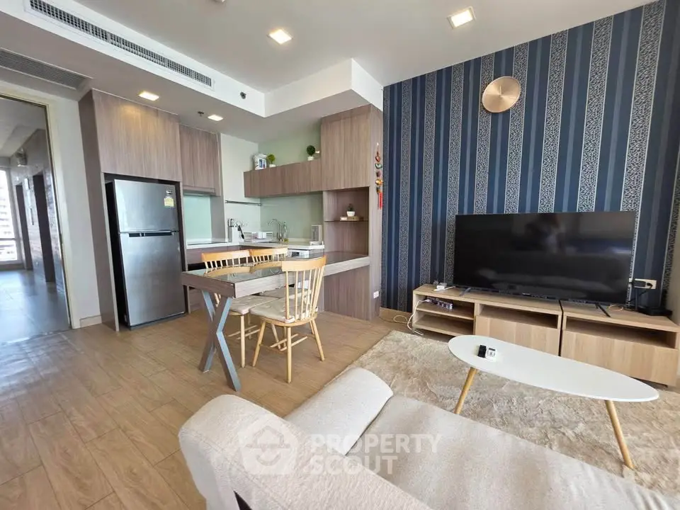 Modern open-layout living room with kitchen, featuring stylish furniture and contemporary design.