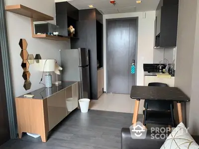 Modern studio apartment with sleek kitchen, stainless steel appliances, and a cozy dining area, perfect for urban living.