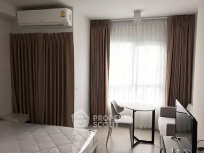 Modern studio apartment with natural light and cozy furnishings.