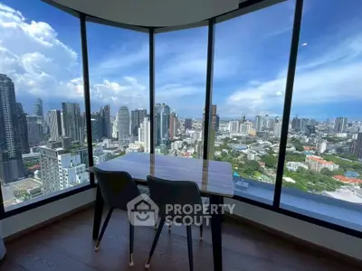 Stunning cityscape view from a high-rise apartment with floor-to-ceiling windows and modern dining area.