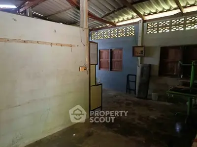 Rustic unfinished interior with exposed beams and concrete floor, potential for renovation.