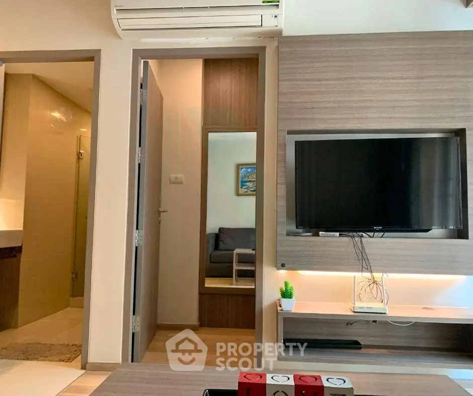 Modern living room with wall-mounted TV and air conditioning in stylish apartment.
